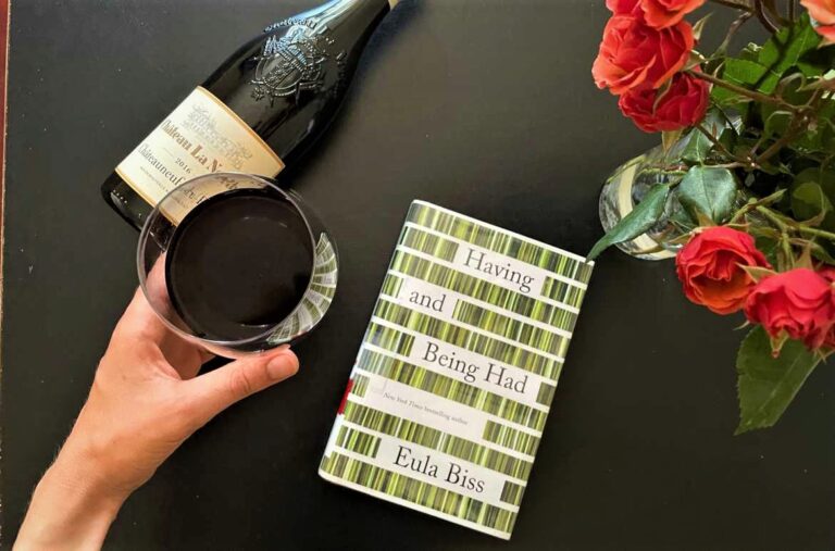 Book and wine with roses on table