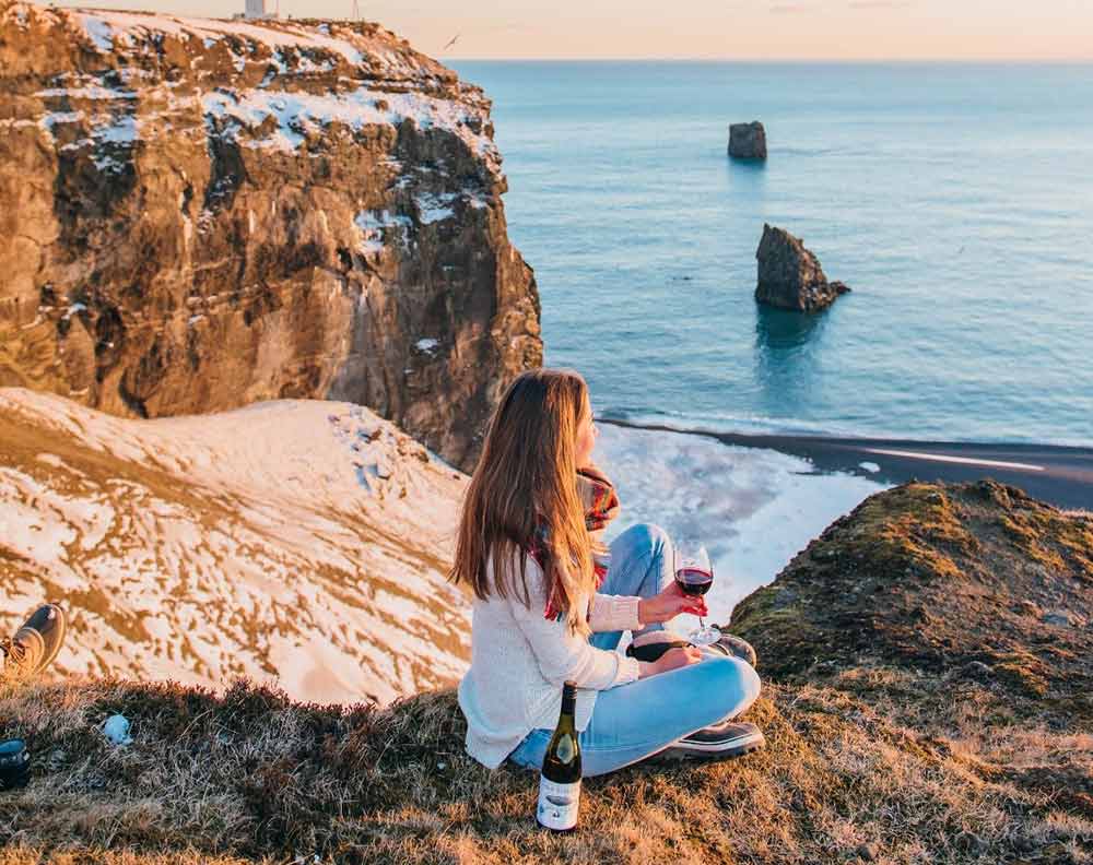 Woman drinking red wine with view of the sea