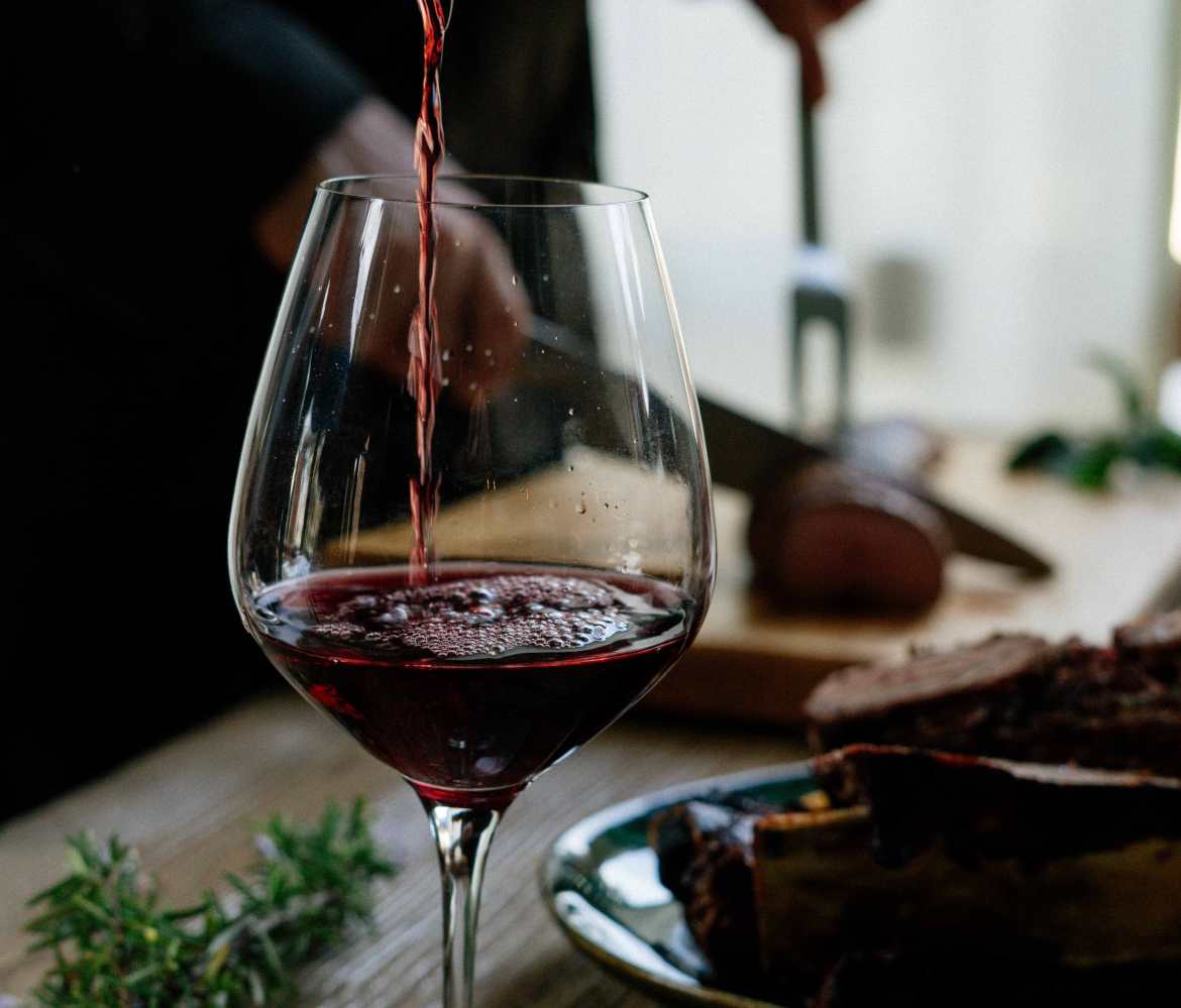 Red wine poured in glass at table
