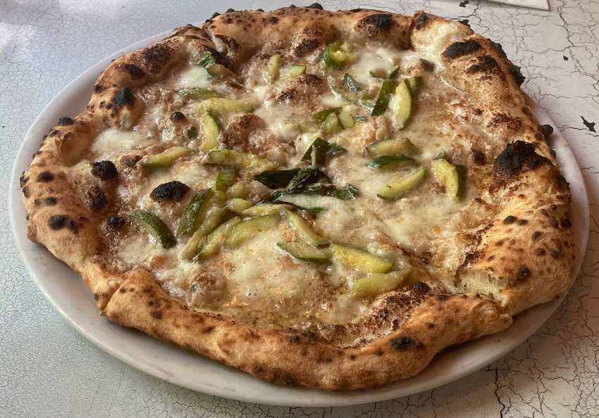 Zucchini pizza topped with walnut cream, zucchini, smoked provolone, and extra virgin olive oil