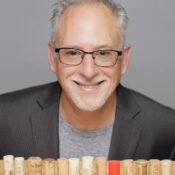 Photo of wine entertainer Bill "Tish" Tisherman with corks in front of him