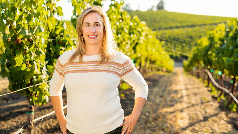 Remi Cohen standing in front of the Domaine Carneros chateau, a medieval-style building modeled after Champagne Taittinger's historic Château de la Marquetterie